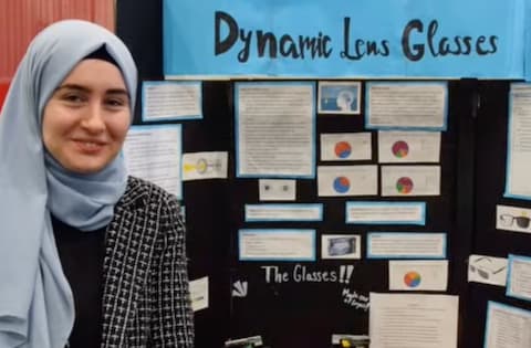 Student in a hijab presenting her Dynamic Lens Glasses project.